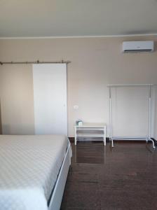 a white bedroom with a bed and a table at B&B Mazzini in Grottaglie