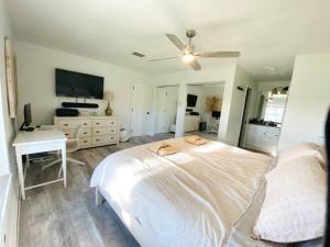 een slaapkamer met een bed, een bureau en een televisie bij Casa de Emma - a 3-bed gulf access vacation home in Cape Coral