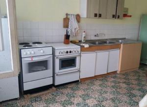 uma cozinha com um fogão branco e um lavatório em Unique 100 y old Dalmatian 3 bedrooms House, under mountain, 14km NP KRKA,30 mins drive to beach em Razvođe