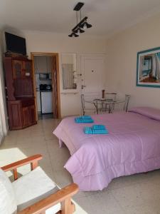 a bedroom with two beds with purple sheets in it at Legarra 1 in Miramar