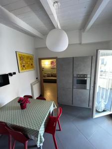 a room with a table and chairs and a kitchen at Attico Stazione - Montello 16 in Bari