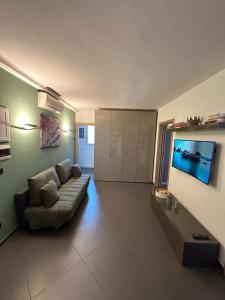 a living room with a couch and a flat screen tv at Attico Stazione - Montello 16 in Bari
