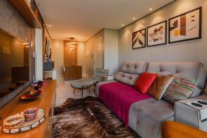 sala de estar con sofá y manta roja en Dom Pedro 304 - Stay House Temporada, en Canela