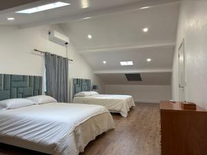 une chambre avec deux lits et une table dans une pièce dans l'établissement Villa Populo, à Ponta Delgada
