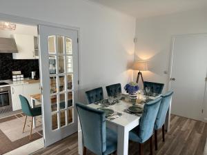 une salle à manger avec une table blanche et des chaises bleues dans l'établissement Villa Populo, à Ponta Delgada