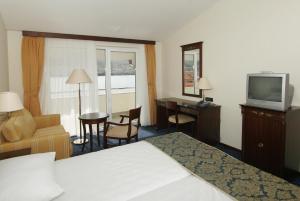 una camera d'albergo con letto, TV e scrivania di Hotel Meridijan a Pag