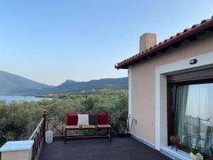 a bench on a balcony with a view of the water at villa kastanos in Amaliapoli