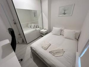 ein weißes Zimmer mit einem Bett und einem Spiegel in der Unterkunft The Trinity College Townhouse in Dublin