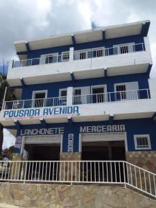un bâtiment bleu et blanc avec l'aquarium pueblo dans l'établissement Pousada avenida 03, à São Thomé das Letras
