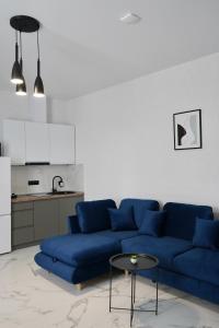 uma sala de estar com um sofá azul e uma mesa em Апарт-готель LOGOS em Skhidnitsa