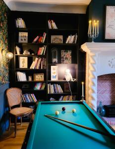 a billiard table in a room with a fireplace at Domaine Le Clos de la Source - Petit déjeuner buffet in Montrichard