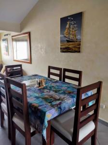 a dining room with a table and a ship on the wall at Cozy Condo in Costambar Beach in San Felipe de Puerto Plata
