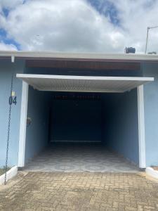 a garage with awning on a blue building at HOTEL E POUSADA ISIS in São Pedro