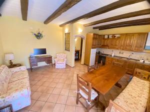 a living room with a table and a kitchen at La Luna di Mezzanotte in Fratta Todina