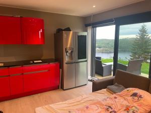 a kitchen with red cabinets and a stainless steel refrigerator at VacationNorway in Froland Verk