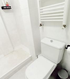 La salle de bains blanche est pourvue de toilettes et d'une baignoire. dans l'établissement SWEET HOME BILBAO, à Bilbao