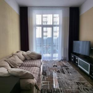 a living room with a couch and a large window at Cozy Apartment in Lviv