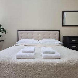 a large bed with two white towels on it at Cozy Apartment in Lviv