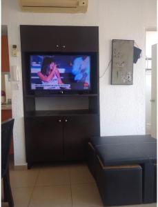 a living room with a flat screen tv on a wall at Twin Towers Acapulco (Caleta) in Acapulco