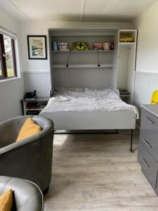 - une petite chambre avec un lit et un canapé dans l'établissement Ade's River Cabin, à Lettermacaward