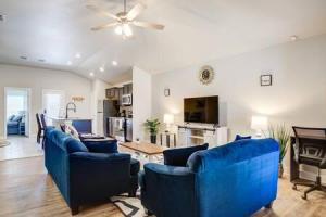 sala de estar con sillas azules y ventilador de techo en Milano Lodge - Cozy Retreat, en Lubbock