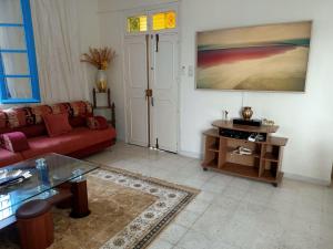 uma sala de estar com um sofá vermelho e uma mesa em Villa Doudi em Al Ḩārah al Kabīrah