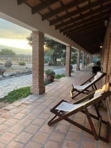聖卡洛斯的住宿－La Vaca Tranquila，两把木制躺椅坐在庭院里