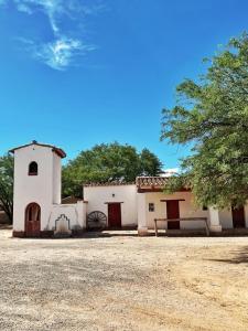 um pequeno edifício branco com uma árvore em frente em La Vaca Tranquila em San Carlos