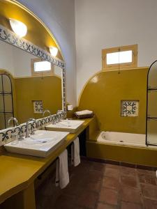 a bathroom with two sinks and a bath tub at La Vaca Tranquila in San Carlos