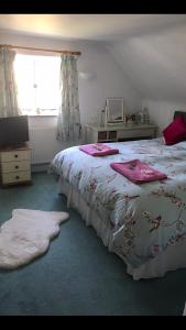 a bedroom with a large bed with pink towels on it at Blue Shutters in Weymouth