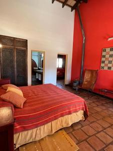 Schlafzimmer mit einem großen Bett mit roten Wänden in der Unterkunft La Vaca Tranquila in San Carlos