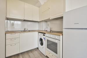 a kitchen with white cabinets and a washer and dryer at Delta Planet budget flat 2 guests in Varna City