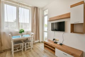 una pequeña sala de estar con mesa y TV. en Delta Planet budget flat 2 guests en Varna