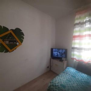 a small bedroom with a bed and a television at Studio Viola in Kraków