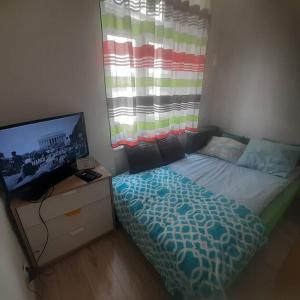 a bedroom with a bed and a flat screen tv at Studio Viola in Kraków