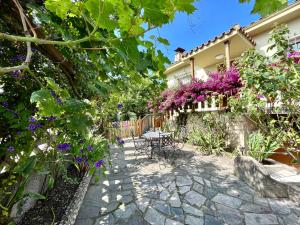 un giardino con fiori viola e tavolo e sedie di La Casa de la Buganvilla a Gijón