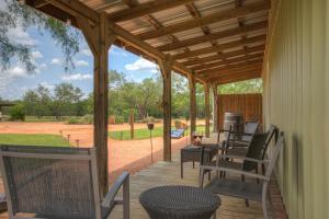 a porch with chairs and a wooden pergola at Lucinda Luxury RV with Hot Tub in Fredericksburg