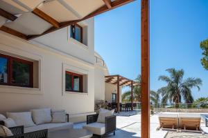 an outdoor patio with a couch and chairs and a table at Angels Villa Chania in Kambánion