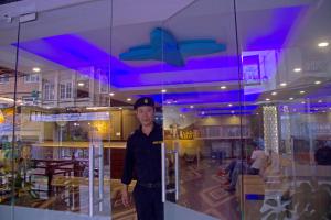 a man standing in front of a glass window at Hotel Simal in Kathmandu