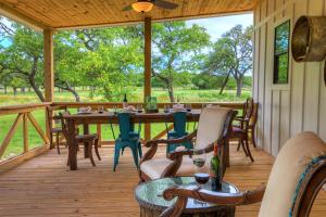 a screened in porch with a table and chairs at 3 Acres of Luxury and Views in Fred Wine Country! in Fredericksburg