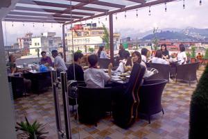 a group of people sitting at tables in a restaurant at Hotel Simal in Kathmandu