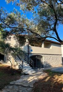 un edificio con una puerta y escaleras delante en Kuća za odmor Krk, en Krk