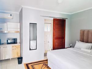 a bedroom with a white bed and a red window at Decent Stay in Durban