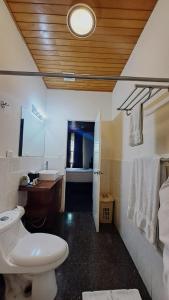 y baño con aseo blanco y lavamanos. en Cardedeu Suites en San Salvador