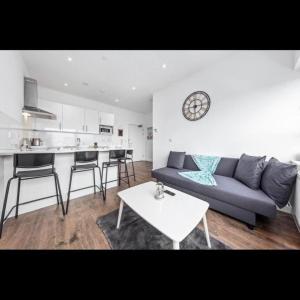 a living room with a couch and a table at London Delta's Gem 1BR 15 mins to London Bridge in Croydon