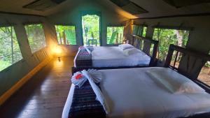 a bedroom with two beds in a tree house at Rio Tico Safari Lodge in Punta Mala