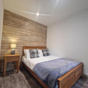 a bedroom with a bed and a wooden wall at Brookside Cottages in Ingoldmells