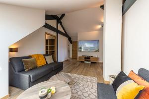 a living room with a couch and a tv at ANNECY HAPPY LODGE DUPLEX 9 pers in Saint-Jorioz