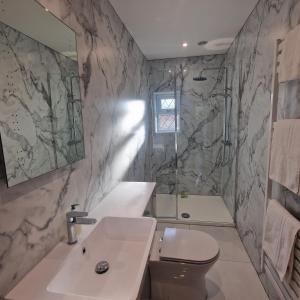 a bathroom with a sink and a toilet and a shower at Brookside Cottages in Ingoldmells
