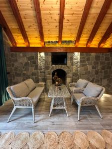 un patio con 2 sillas y una chimenea en Özen Villa Apart, en Uzungöl